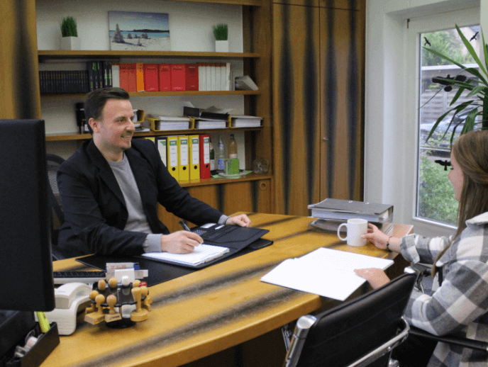 Optikerin die einer Dame die Brille richtet